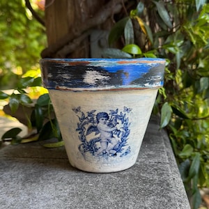 May include: A white ceramic mug with a black handle and the text "But First, Coffee" in a bold, black font. The mug is set against a neutral background, highlighting its simple design.