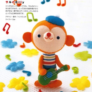 May include: A plush toy monkey wearing a blue beret and a striped shirt, holding a green guitar. The monkey has orange fur and a white face with black eyes and a red nose. The background is white with colorful musical notes and flowers.