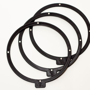 May include: Three black speaker mounting rings with a small tab on each ring.