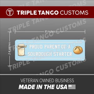 May include: A light blue rectangular sticker, 8 inches long and 2.4 inches high, with the text "PROUD PARENT OF A SOURDOUGH STARTER". It features illustrations of a jar of starter and a loaf of bread. The sticker is from Triple Tango Customs.