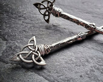 May include: Two silver key-shaped charms with a Celtic knot design. The charms have a textured, twig-like handle.