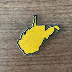 May include: A set of three ceramic mugs with a speckled, matte finish. The mugs are in shades of cream, light gray, and dark gray. Each mug has a simple, modern design and a rounded handle.