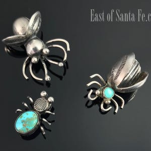 May include: Three silver and turquoise beetle brooches. The brooches are detailed and feature turquoise stones.