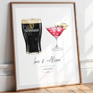 Op de afbeelding: Een ingelijste print met een donker stoutbier in een glas met het Guinness-logo en een roze cocktail in een martiniglas met een schijfje limoen en kersen. Onder de drankjes staat de tekst Ian & Alison, A TRUE MATCH met een klein rood hartje.
