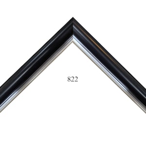 May include: A black and silver picture frame with a beveled edge. The frame has a number "822" printed on it.