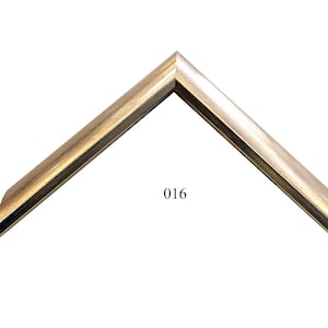 May include: A gold-colored picture frame with a beveled edge. The frame is labeled "016".