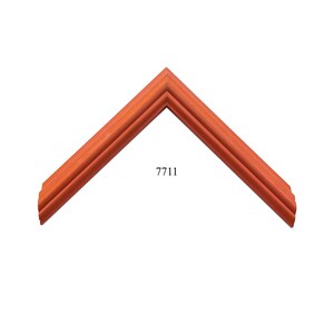 May include: A corner section of a picture frame with a warm, reddish-orange wood grain finish. The frame features a stepped, multi-layered profile with distinct ridges and grooves. The number 7711 is printed in black text in the center area.