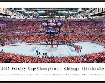 May include: Panoramic framed photograph of the 2015 Stanley Cup Champions, the Chicago Blackhawks, celebrating on the ice. The arena is filled with cheering fans wearing red. The text "2015 Stanley Cup Champions - Chicago Blackhawks" is displayed.