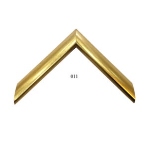 May include: A gold-colored picture frame corner sample with a smooth, metallic finish and a mitered joint. The frame profile features a simple, angled design. The number 011 is printed in black in the center of the V-shaped frame corner piece.