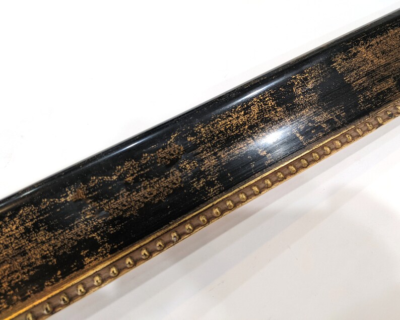 May include: A black picture frame with a gold trim and a decorative pattern of gold dots along the edge.