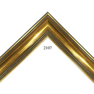 May include: A gold picture frame corner sample featuring a multi-tiered profile with a smooth central band and a beaded inner edge. The frame has a metallic finish with dark accents in the recessed areas. The number 2107 is printed in black.