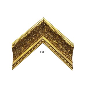 May include: A corner section of a picture frame featuring an ornate, embossed floral and scrollwork pattern in a metallic gold finish. The frame has a deep, recessed profile with raised edges and the number 4311 printed in black on the surface.