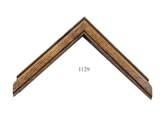 May include: A close-up of a wooden picture frame corner with a dark brown stain. The frame has a simple, classic design with a slightly raised edge. The number 1129 is printed on the frame.