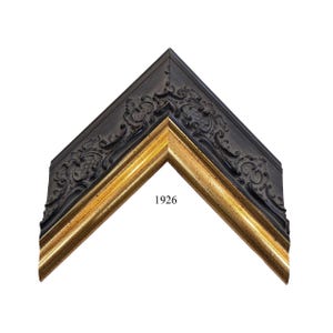 May include: A corner section of a picture frame featuring a dark black outer edge with intricate embossed scrollwork patterns and a smooth, metallic gold inner border. The number 1926 is printed in black text near the center of the frame corner.