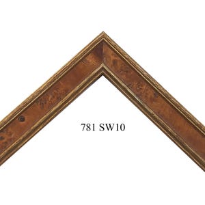 May include: An L-shaped corner section of a picture frame featuring a rich brown wood grain pattern with burl wood textures and gold-toned trim along the inner and outer edges. The text 781 SW10 is printed in black in the center of the frame.