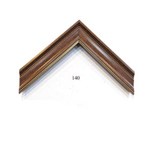May include: A close-up of a brown picture frame with a gold trim. The frame is angled to show the corner. The number 140 is printed on the white background.