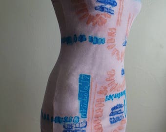 Puede incluir: Un top de tirantes rosa con un diseño abstracto azul y naranja. El top está hecho de tela de canalé.