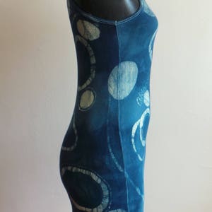 Puede incluir: Un top azul sin mangas con un patr&oacute;n abstracto blanco y azul. El top est&aacute; hecho de tela de canal&eacute;.