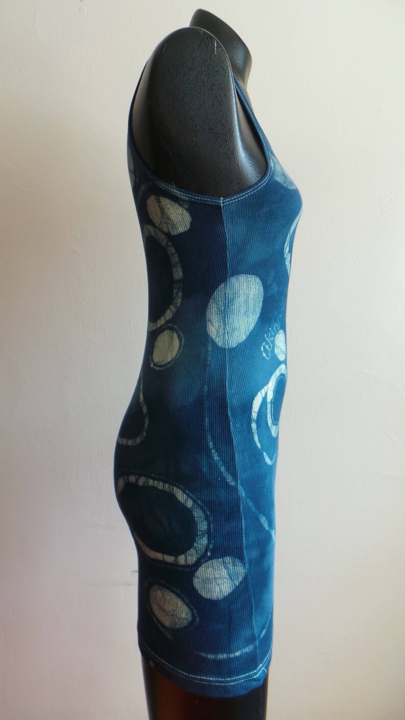 Puede incluir: Un top azul sin mangas con un patr&oacute;n abstracto blanco y azul. El top est&aacute; hecho de tela de canal&eacute;.