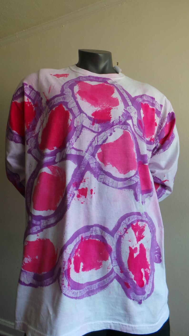 May include: White long-sleeved shirt with a tie-dye pattern of pink and purple circles.