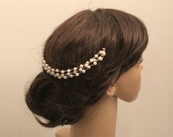 May include: A gold chain hair accessory with white pearl beads. The chain is layered and has a delicate design.