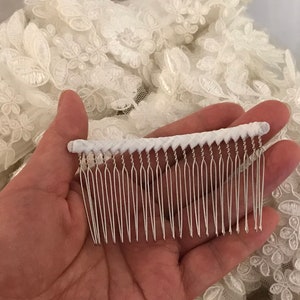 May include: A white comb with a white braided handle and silver metal teeth.