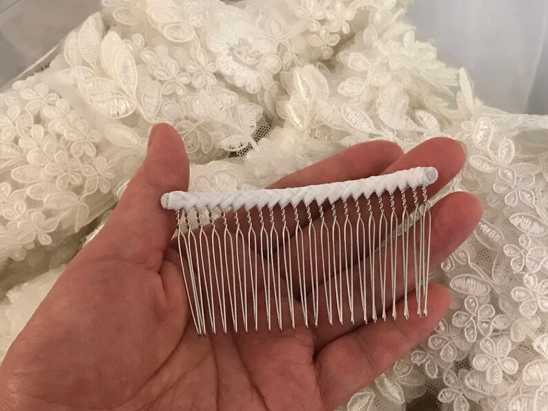 May include: A white comb with a white braided handle and silver metal teeth.
