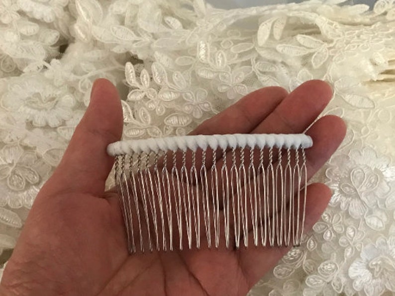 May include: A white comb with a white, beaded edge. The comb has a silver metal base with a row of teeth.