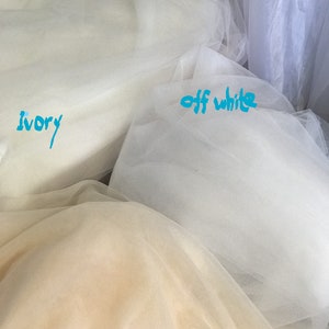 May include: Three swatches of tulle fabric in ivory, off-white, and champagne.