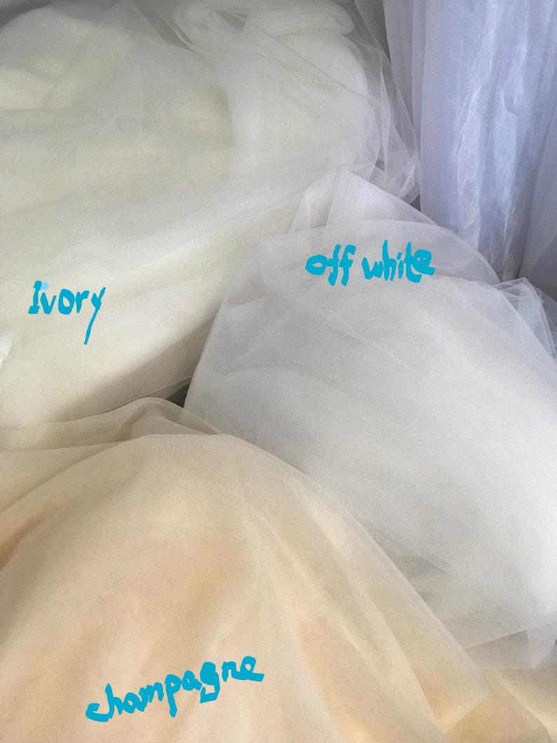 May include: Three swatches of tulle fabric in ivory, off-white, and champagne.