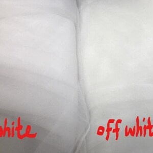 Op de afbeelding: Twee stukken witte stof, een met het label "wit" en de andere met het label "cr&egrave;mewit".