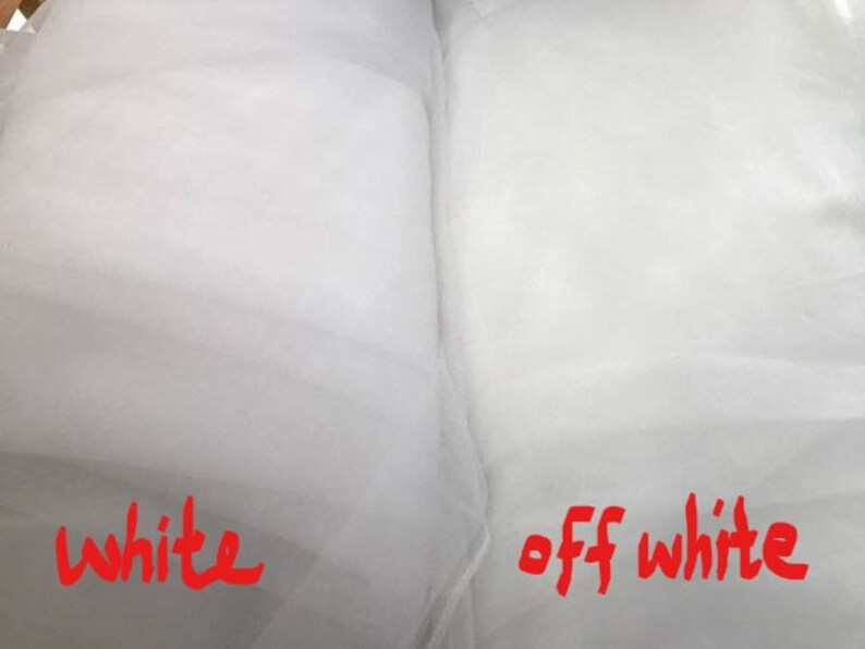 Op de afbeelding: Twee stukken witte stof, een met het label "wit" en de andere met het label "cr&egrave;mewit".