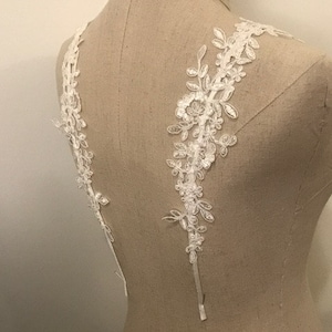Peut inclure: Garniture en dentelle blanche avec des motifs floraux, idéale pour ajouter une touche délicate aux robes de mariée, aux accessoires de mariée ou à d'autres projets d'artisanat.