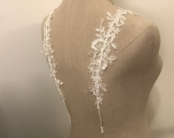May include: White lace trim featuring floral designs, ideal for adding a delicate touch to wedding dresses, bridal accessories, or other craft projects.