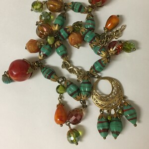 Charm style necklace, vintage textured chain, brass bead caps, faceted green, turquoise w/red stripes, givre glass beads, lucite, crystal