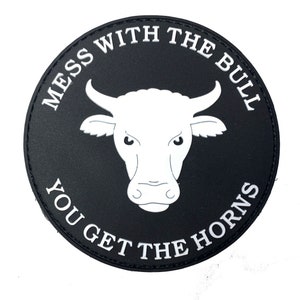 May include: Black and white round patch with the text "Mess with the Bull You Get the Horns" in a circle around a white bull's head.
