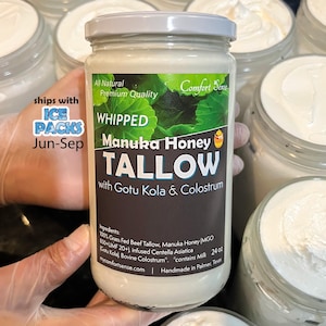 May include: A jar of whipped Manuka Honey Tallow with Gotu Kola & Colostrum. The label reads "All Natural, Premium Quality." The jar is held by a person wearing gloves. Other jars of the product are in the background.