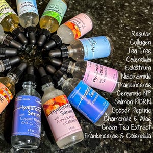 May include: A collection of glass dropper bottles containing Hyaluronic Serum in various formulations, including Collagen, Tea Tree, Calendula, Colostrum, Niacinamide, Frankincense, Ceramide NP, Salmon PDRN, Copper Peptide, Chamomile & Aloe, and Green Tea.