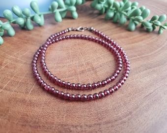 May include: A double strand necklace made of small, dark red garnet beads.