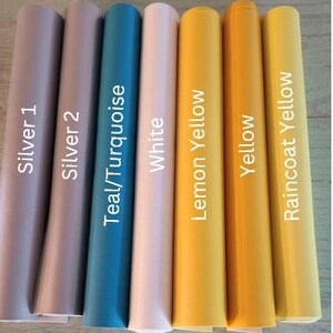 Op de afbeelding: Acht rollen vinyl plakband in verschillende kleuren, waaronder zilver, teal, wit, citroengeel, geel en regenjasgeel. De rollen zijn gelabeld met hun respectievelijke kleuren.
