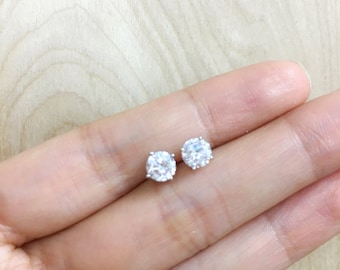 May include: A pair of silver stud earrings with clear round cubic zirconia stones.