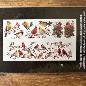 May include: A clear acetate transfer sheet featuring two horizontal rows of illustrations of various birds, including cardinals, perched on branches with red berries. The packaging includes printed instructions and the brand name Prima Marketing.