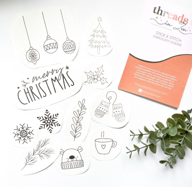 Puede incluir: Una colecci&oacute;n de dise&ntilde;os de bordado navide&ntilde;os en blanco y negro. Incluye adornos, un &aacute;rbol de Navidad, copos de nieve, mitones, un oso y el texto "merry CHRISTMAS". Tambi&eacute;n hay una tarjeta con el texto "threads in zen".