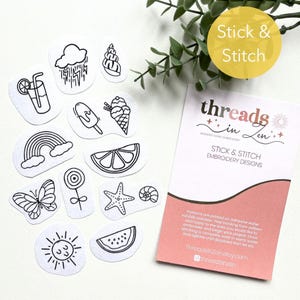 May include: A set of 12 black and white embroidery designs on white paper circles. The designs include a rainbow, a lemon, a butterfly, a watermelon, a sun, a seashell, a popsicle, a glass of lemonade, a cloud with raindrops, a lollipop, a starfish, and an ice cream cone. The designs are labeled "Stick & Stitch Embroidery Designs" and are from the company "threads in zen".
