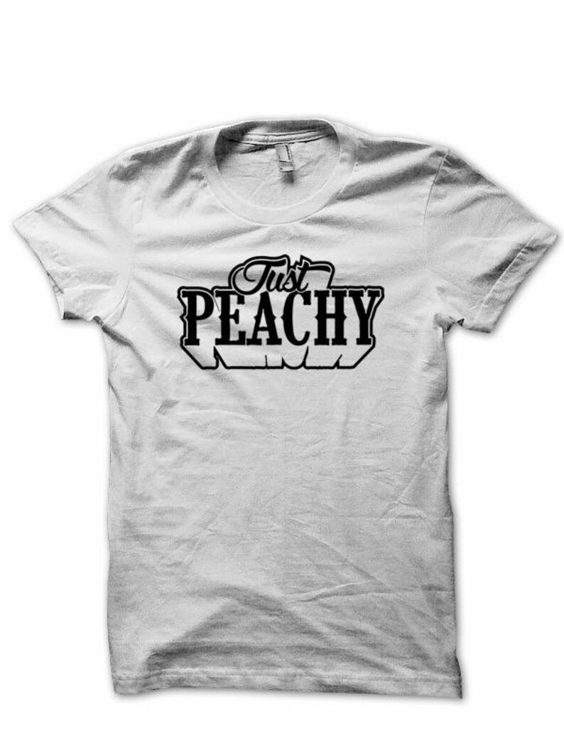 May include: White t-shirt with black text that reads "Just Peachy".