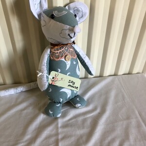 May include: A handmade plush toy mouse with a blue and white fabric pattern. The mouse has a white tag that says "Sky Mouse".