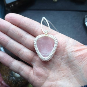 May include: A pink rose quartz pendant with a white macrame cord.