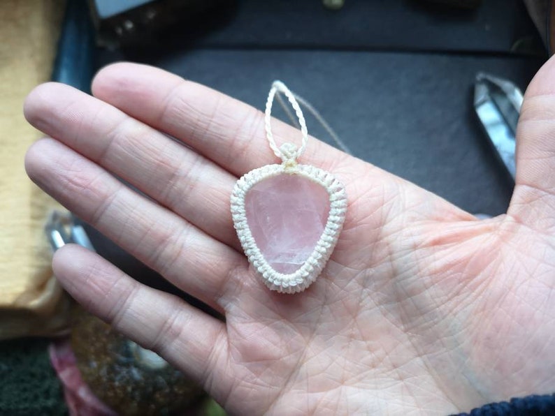 May include: A pink rose quartz pendant with a white macrame cord.
