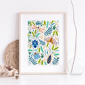 May include: A framed print with a white background and a colorful pattern of insects and leaves. The insects include a dragonfly, a moth, and two beetles. The leaves are green and blue.