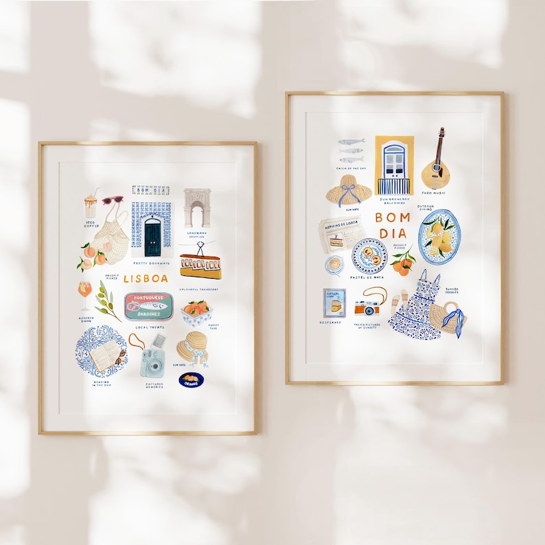 May include: Two framed art prints with gold frames. The left print features illustrations of Lisbon, including a sardine can, pastries, and a camera. The right print says "Bom Dia" and includes a guitar, a dress, and a plate of lemons. Both prints have a white background.